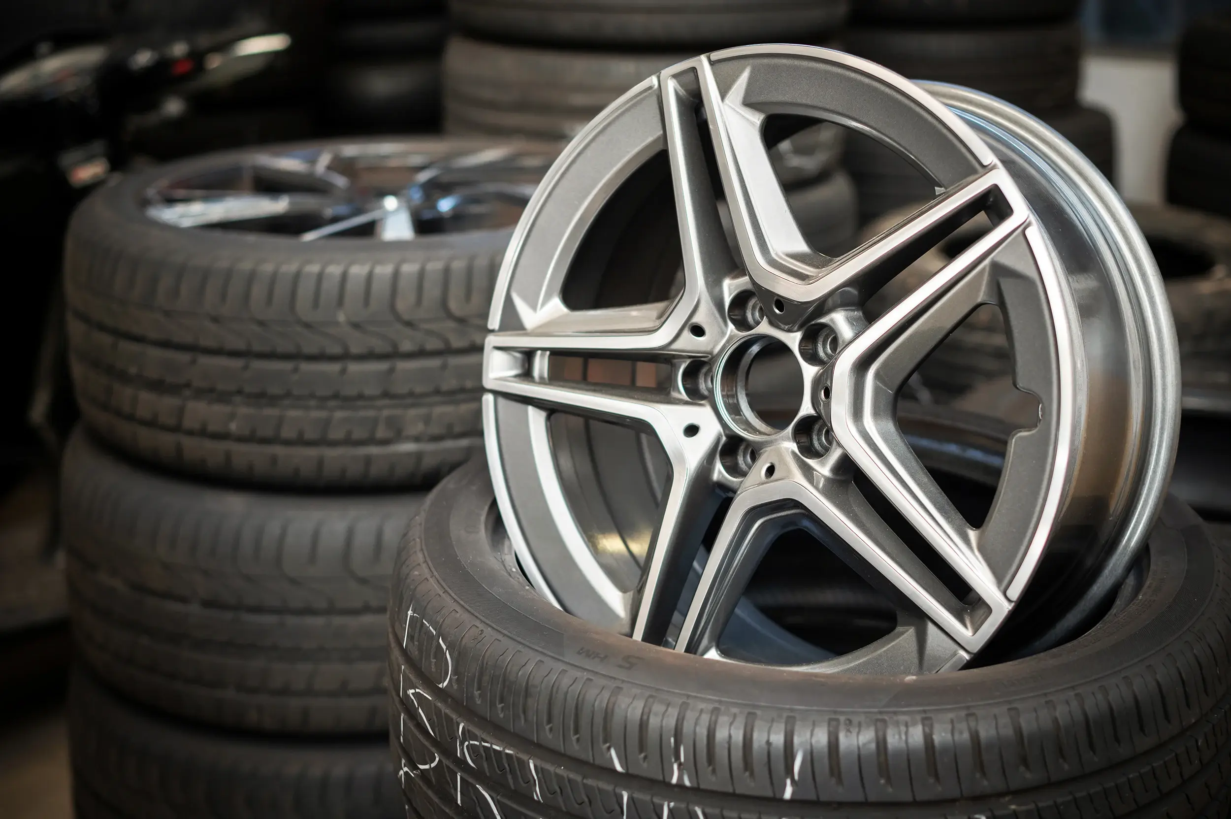 Aluminiowa felga oparta o stos opon — wymiana, wulkanizacja, sprzedaż w CAR-MIG